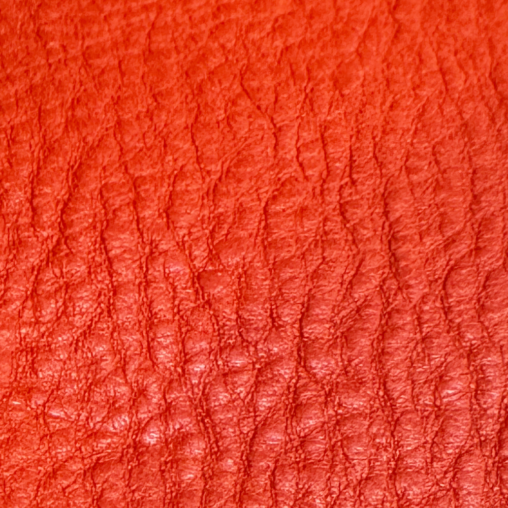Name: Vegetable-Tanned Milled Leather
Material: Top-Grain Cowhide (Vegetable-Tanned)
Surface Finish: Semi-Aniline / Light Breathable Finish (Drum Milled / Tumbled Leather)
Reference Thickness: Approximately 1.2–1.5 mm; customizable to suit specific requirements

Vegetable-Tanned Milled Leather is tanned using natural plant polyphenols (tannins) and processed through a specialized tumbling/milling technique in drums, creating an organic, irregular pebble texture with a supple, elastic, and soft hand-feel. This process overcomes the natural stiffness of traditional veg-tan leather to deliver a rich, flexible grip, while the textured surface naturally conceals minor hide imperfections.
Combining the coveted patina aging potential of veg-tan leather with the tactile warmth of pebbled leather, it offers an exceptional non-slip grip that matures into a personalized finish with daily handling. This material is suitable for everyday accessories such as smartphone cases, tablet sleeves, mini wallets, cardholders, and phone lanyards.